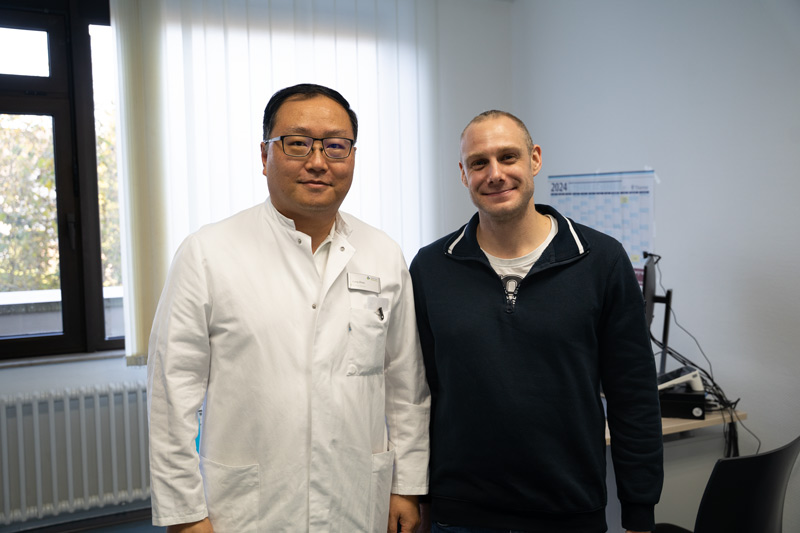 Der Leitende Oberarzt Liang Zhou gemeinsam mit Patient Jan Plomann