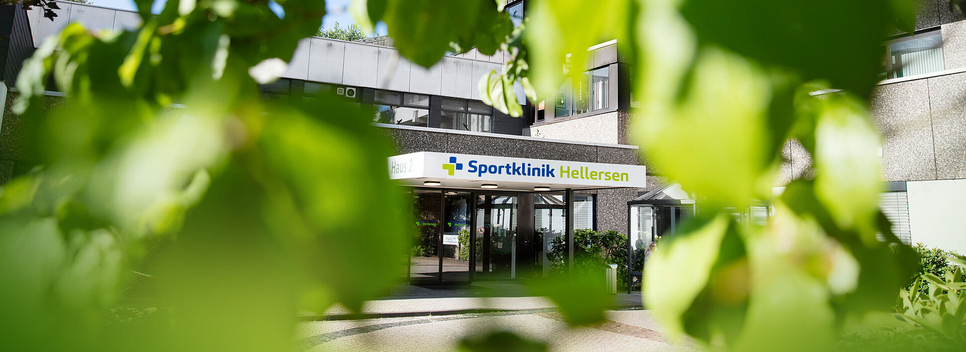 Aufnahme des Haupteingangs der Sportklinik Hellersen aus der Perspektive der umgebenden Natur