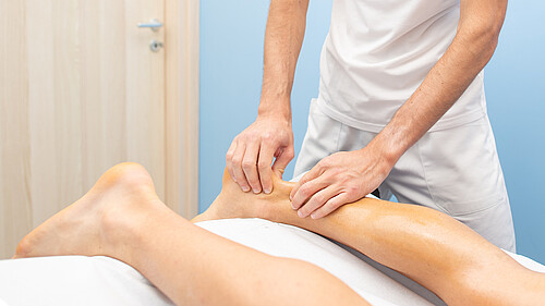 Physiotherapeutin bei einer Achillessehnenbehandlung.